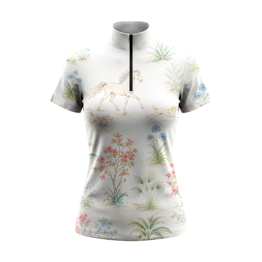 Studio white‑background product mockup of off‑white short‑sleeve quarter‑zip riding top with all‑over vintage watercolor galloping‑horse, running‑hound and botanical floral print