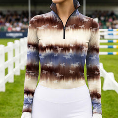 Full-body model shot wearing blurred gradient tie-dye galloping horse long sleeve top at outdoor equestrian show jumping arena with spectator stands, holding riding crop
