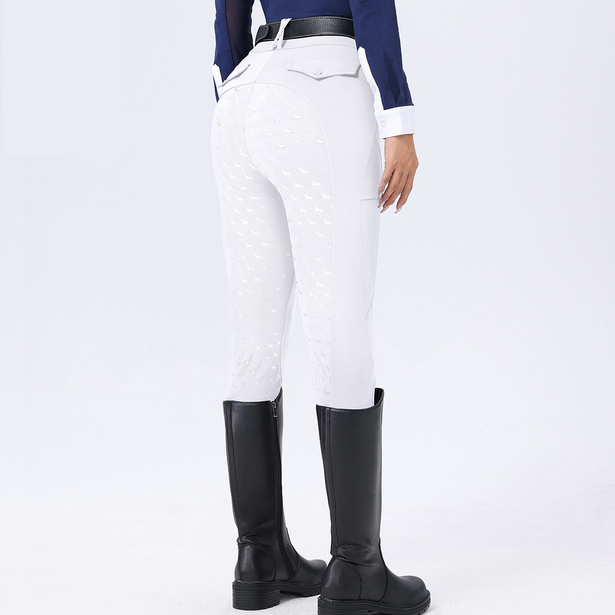 Person wearing white riding pants and black riding boots on a light gray background