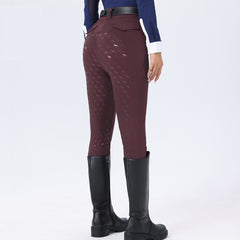 Maroon riding pants with pattern, black riding boots, and blue top on a white background