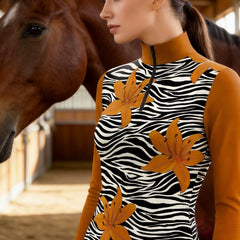 Close-up side portrait of the model beside a horse inside a timber stable showcasing zebra stripe lily floral print detailing
