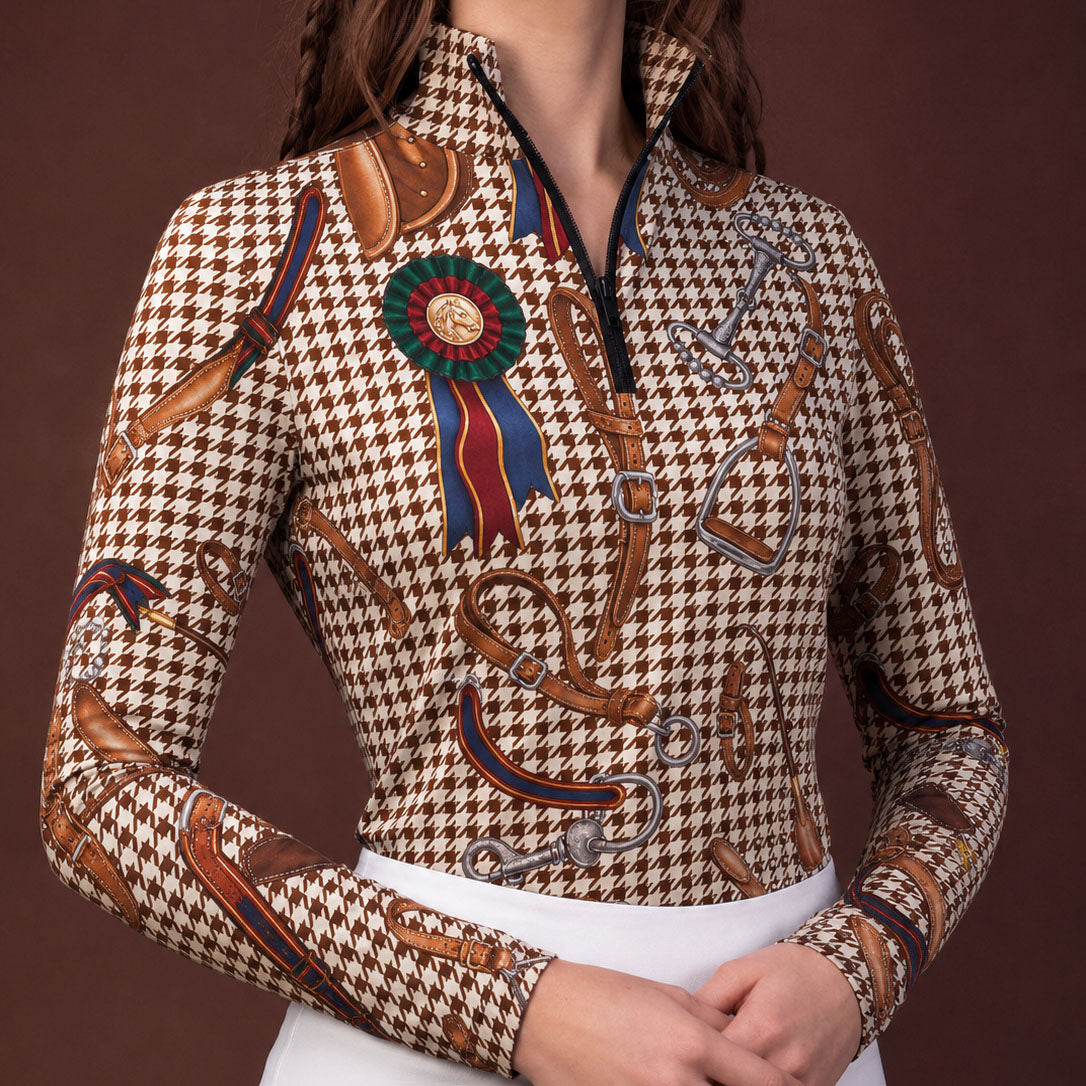 Clean white background studio product mockup of dark charcoal long‑sleeve quarter‑zip riding top showcasing vintage golden equestrian tack, zebra stripe and leopard spot all‑over mixed‑motif print