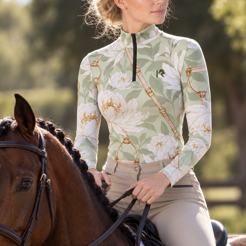Barn lifestyle shot of the riding top worn by a rider mounted on horseback