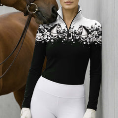 Cropped front lifestyle view of the top worn by a woman leaning against a wall next to a horse