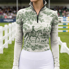 Model wearing the off white printed riding top standing in a show jumping arena with white fencing and jump obstacles