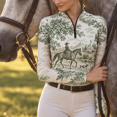 Model wearing the off white printed riding top standing next to a gray horse in a sunlit grassy outdoor area