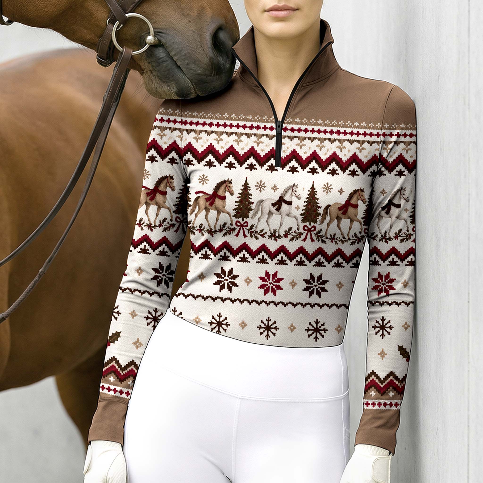Woman wearing the Brown long sleeve quarter zip riding top with white breeches and brown leather belt while holding reins next to a chestnut horse outdoors