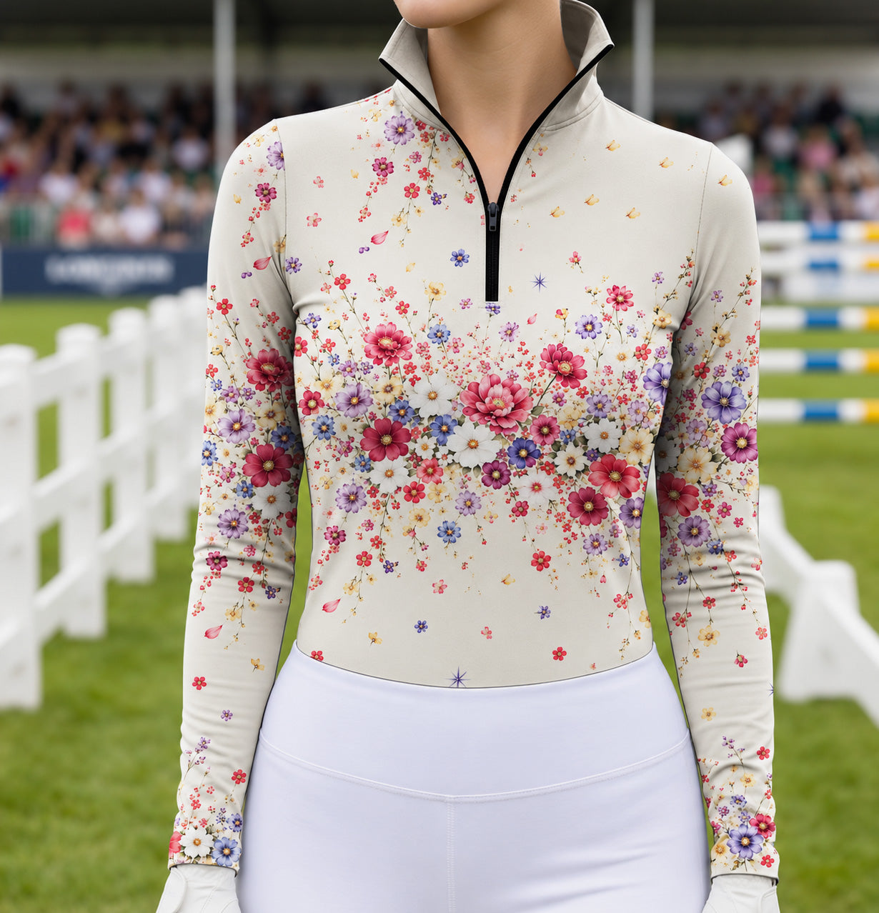 Woman wearing the cream floral print long sleeve quarter zip riding top with white riding breeches near a horse