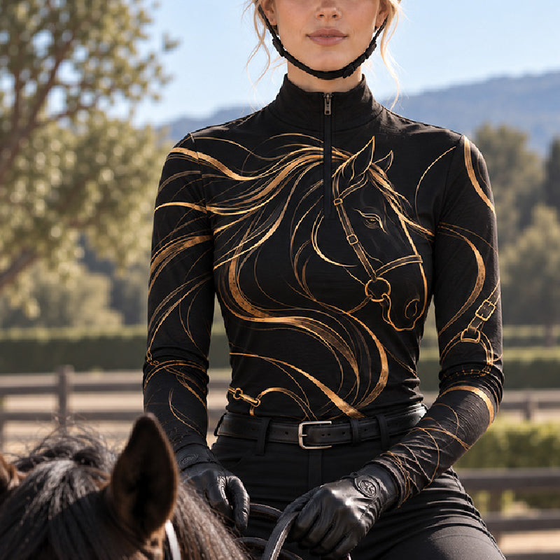 Black quarter zip riding top with gold horse line art worn while mounted with black riding gloves and a helmet