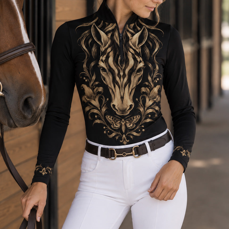 Close view of gold scroll style cuff print on black long sleeve quarter zip riding top
