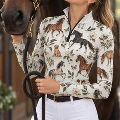 Woman wearing the printed long sleeve quarter zip riding top with white high waisted riding breeches beside a brown horse