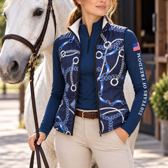 Navy chain print reversible quilted vest worn with navy quarter zip top and beige breeches in an equestrian barn setting