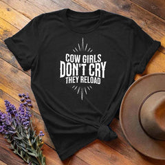 Black "Cow Girls Don't Cry They Reload" western equestrian t-shirt, flat lay on wooden background