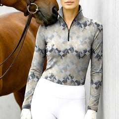 Woman wearing RIDER ATELIER brushstroke geo horse head taupe-gray equestrian quarter-zip top at the barn with a chestnut horse