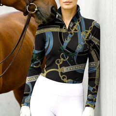 Woman wearing RIDER ATELIER equestrian belt & bow black gold quarter-zip top at the barn with a chestnut horse