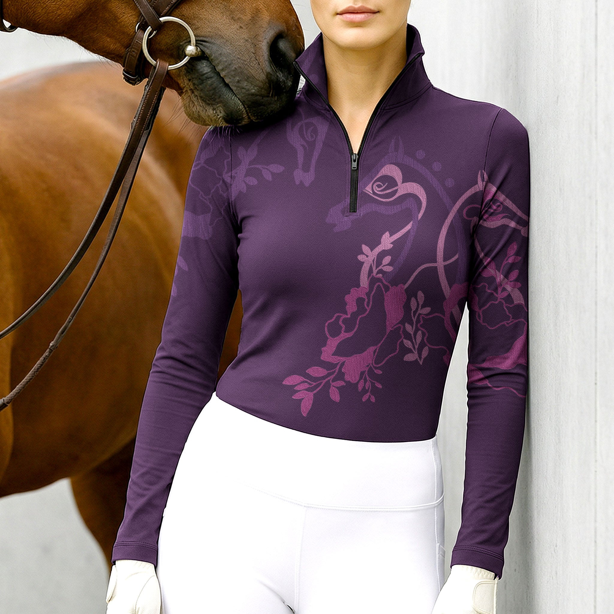 Woman wearing RIDER ATELIER floral horse silhouette plum quarter-zip top at the barn with a chestnut horse