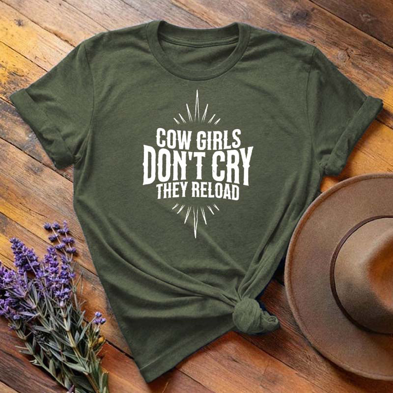 Olive green "Cow Girls Don't Cry They Reload" western equestrian t-shirt, flat lay on wooden background