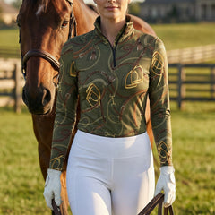 Woman wearing olive green equestrian tack allover print quarter-zip top standing with a a chestnut horse at the stable