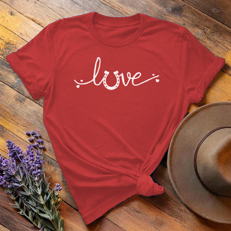 Red horse shoe love equestrian t-shirt with white script print, flat lay on wooden background