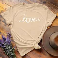 Tan horse shoe love equestrian t-shirt with white script print, flat lay on wooden background