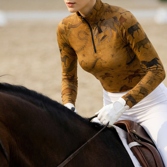 Close-up of woman riding horse wearing tan vintage equestrian allover print quarter-zip riding top at the stable