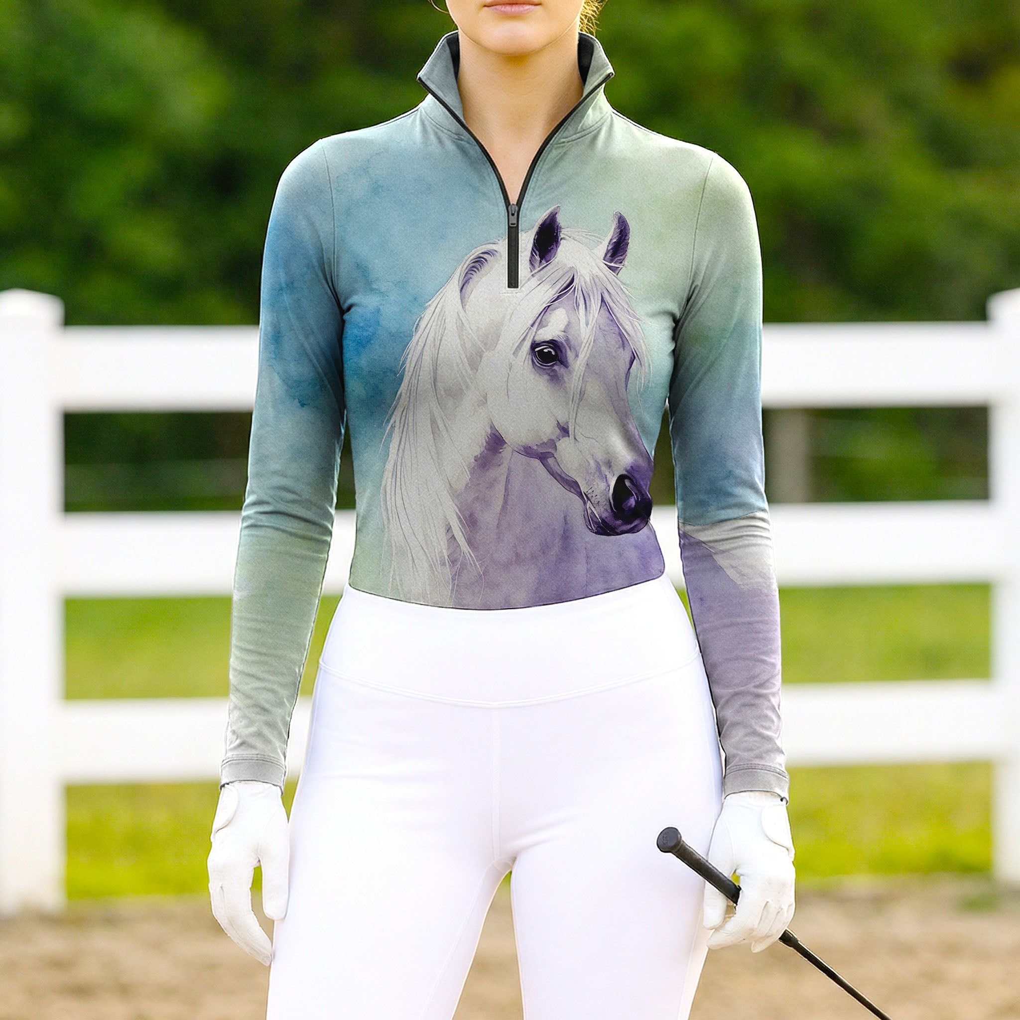 Woman wearing RIDER ATELIER watercolor white horse ombre teal-purple equestrian quarter-zip top at the outdoor pasture