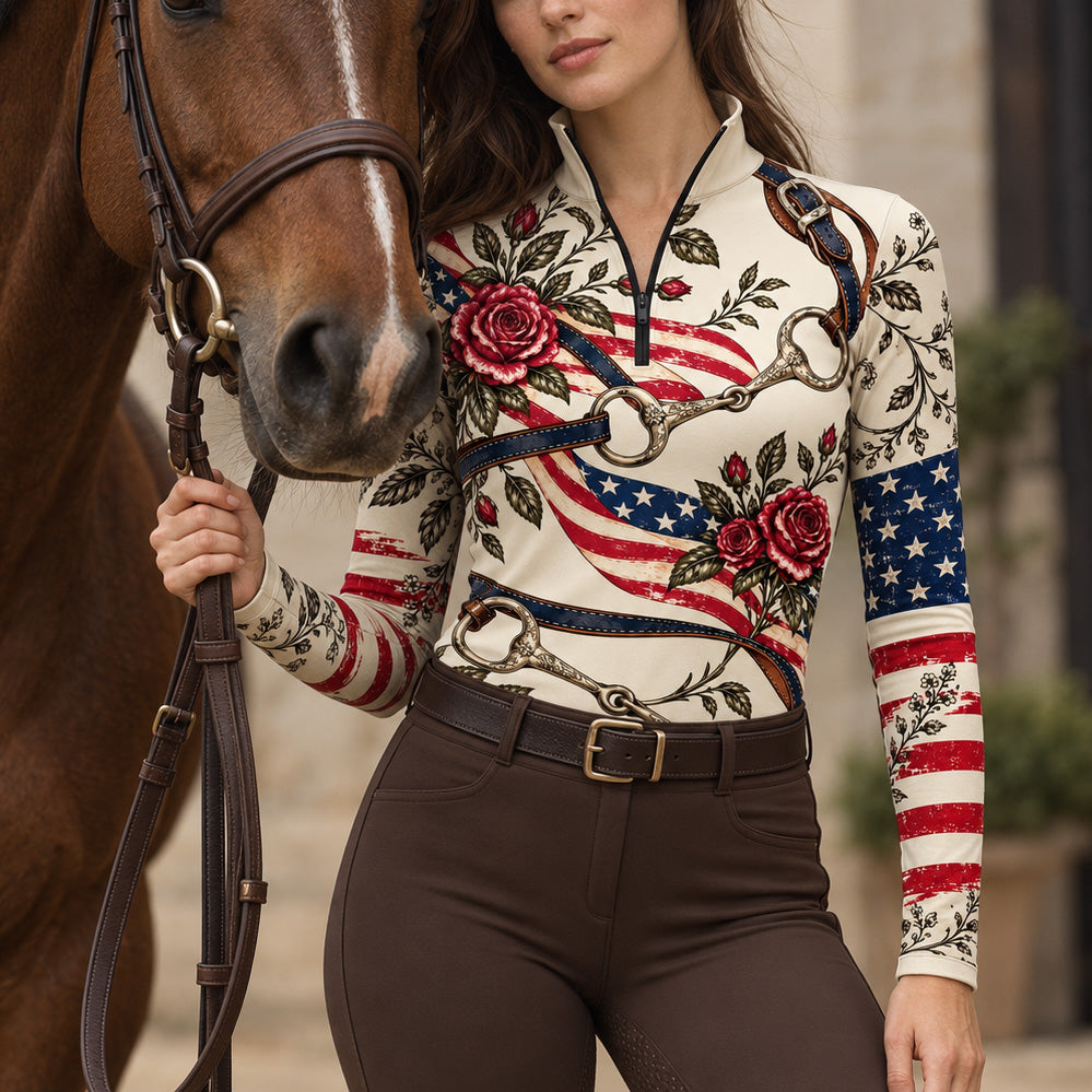Woman wearing the cream printed riding top with brown breeches while holding a brown horse by leather reins
