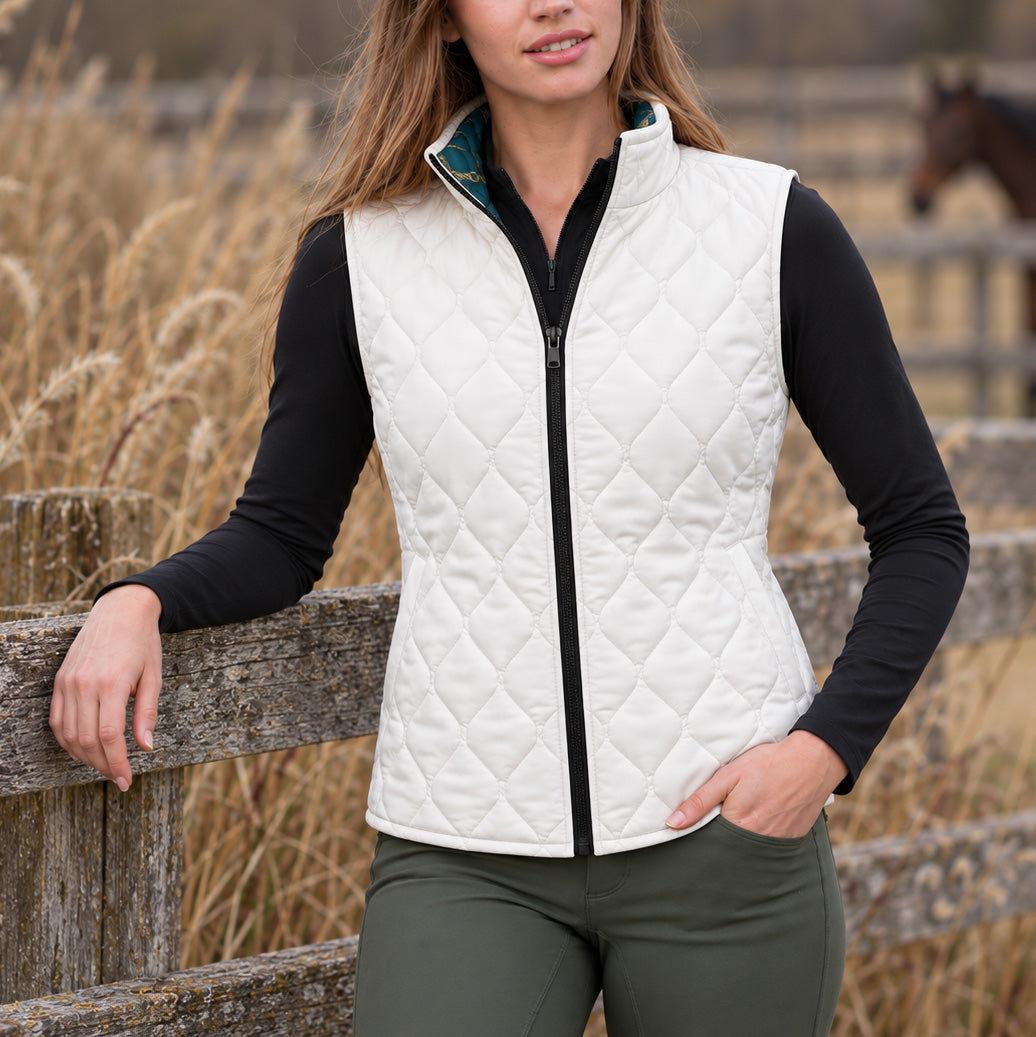 Solid white diamond quilted side of reversible equestrian vest worn near a wooden fence