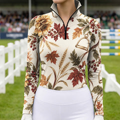 Close view of the cream printed long sleeve quarter zip riding top showing the stand up collar, black zipper and all over sunflower and equestrian hardware print
