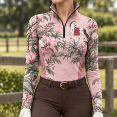 Back view of the light pink floral horse print riding top with darker pink side panels, worn with brown riding breeches and tall brown riding boots