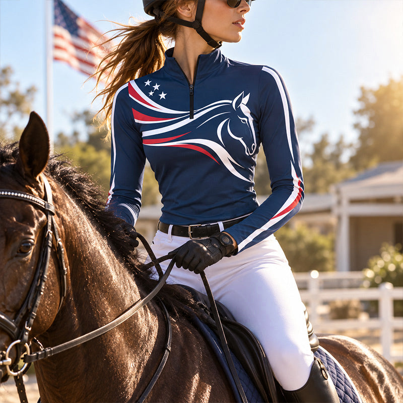 Model wearing navy riding top near a saddled brown horse and white wooden fencing