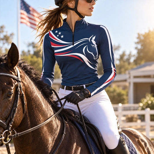 Model wearing navy riding top near a saddled brown horse and white wooden fencing