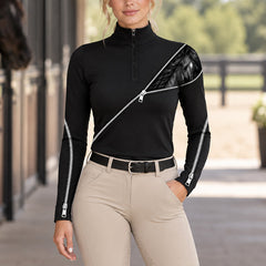 Woman wearing the riding top outside a barn paired with beige riding breeches