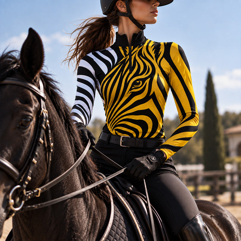 Model wearing the yellow zebra print riding top while riding a dark brown horse outdoors under a blue sky