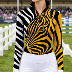 Yellow long sleeve quarter zip riding top with zebra line art print and visible hem stitching against a show jumping arena background